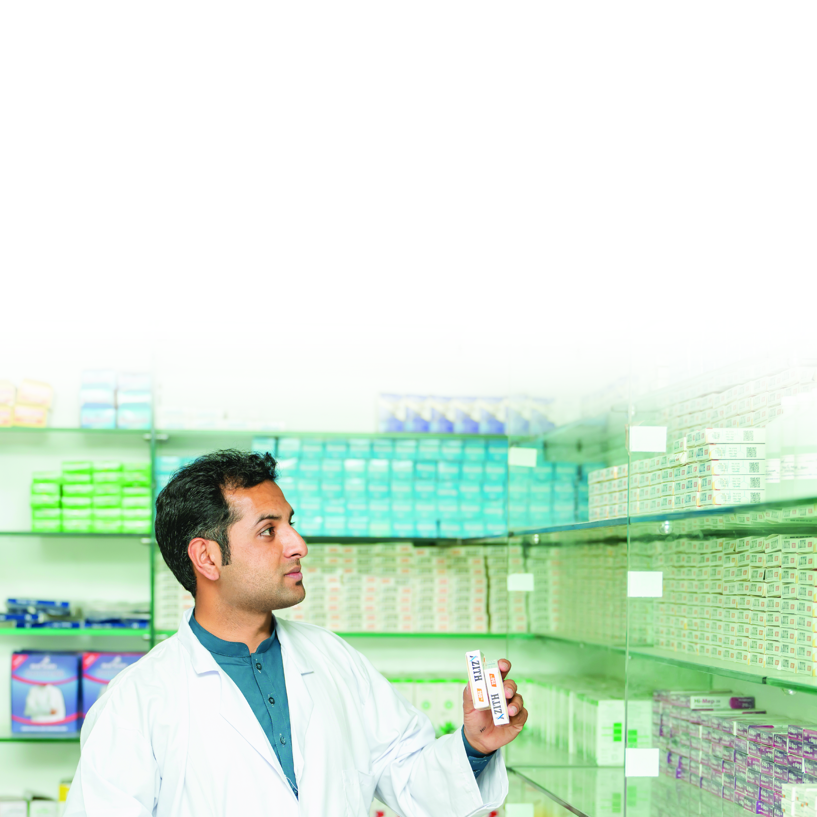 man in lab coat stocking medicine in a pharmacy