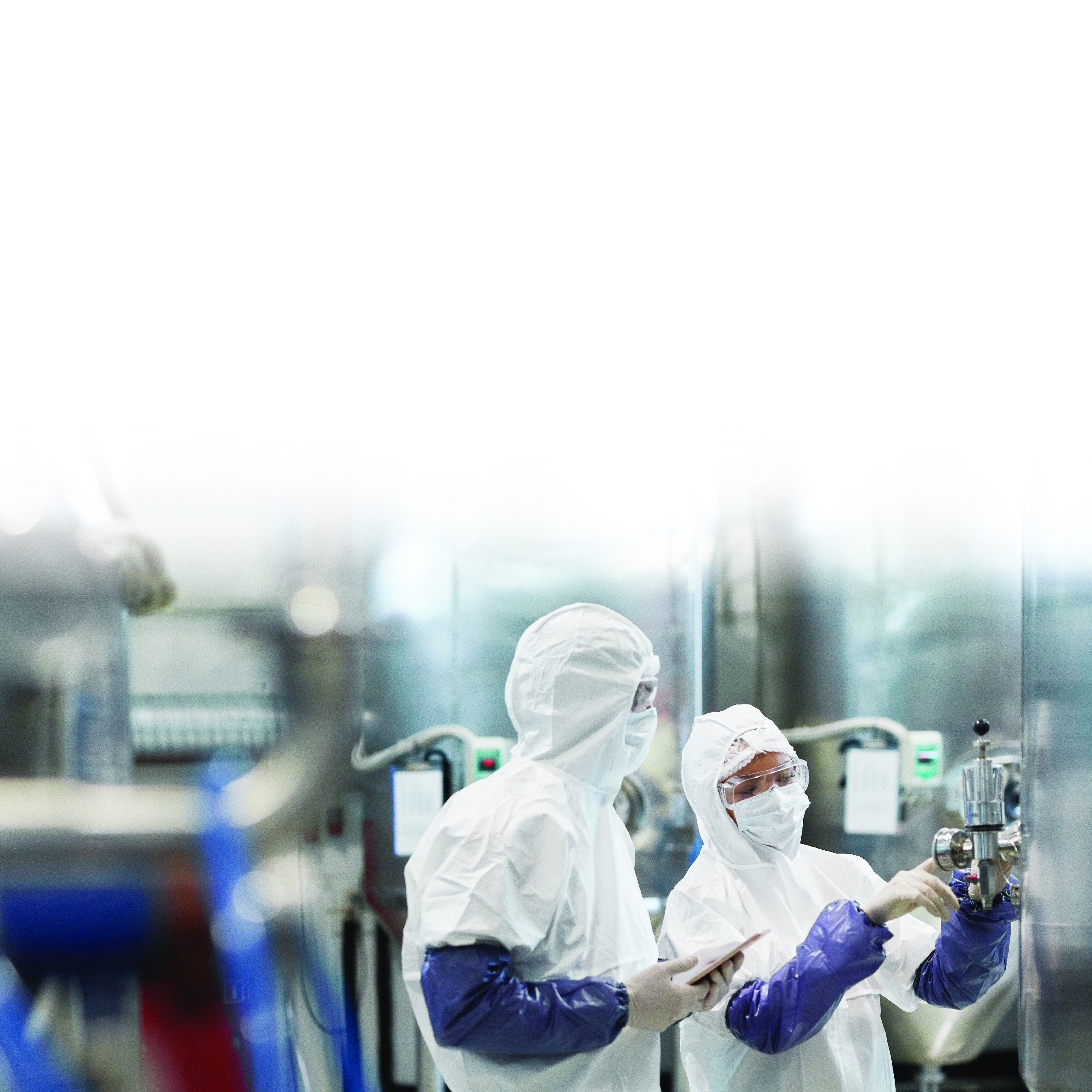 People in protective suits and masks working in a factory