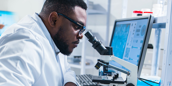 scientist looking into a microscope in a lab