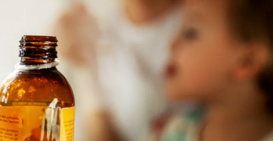 child with cough syrup bottle